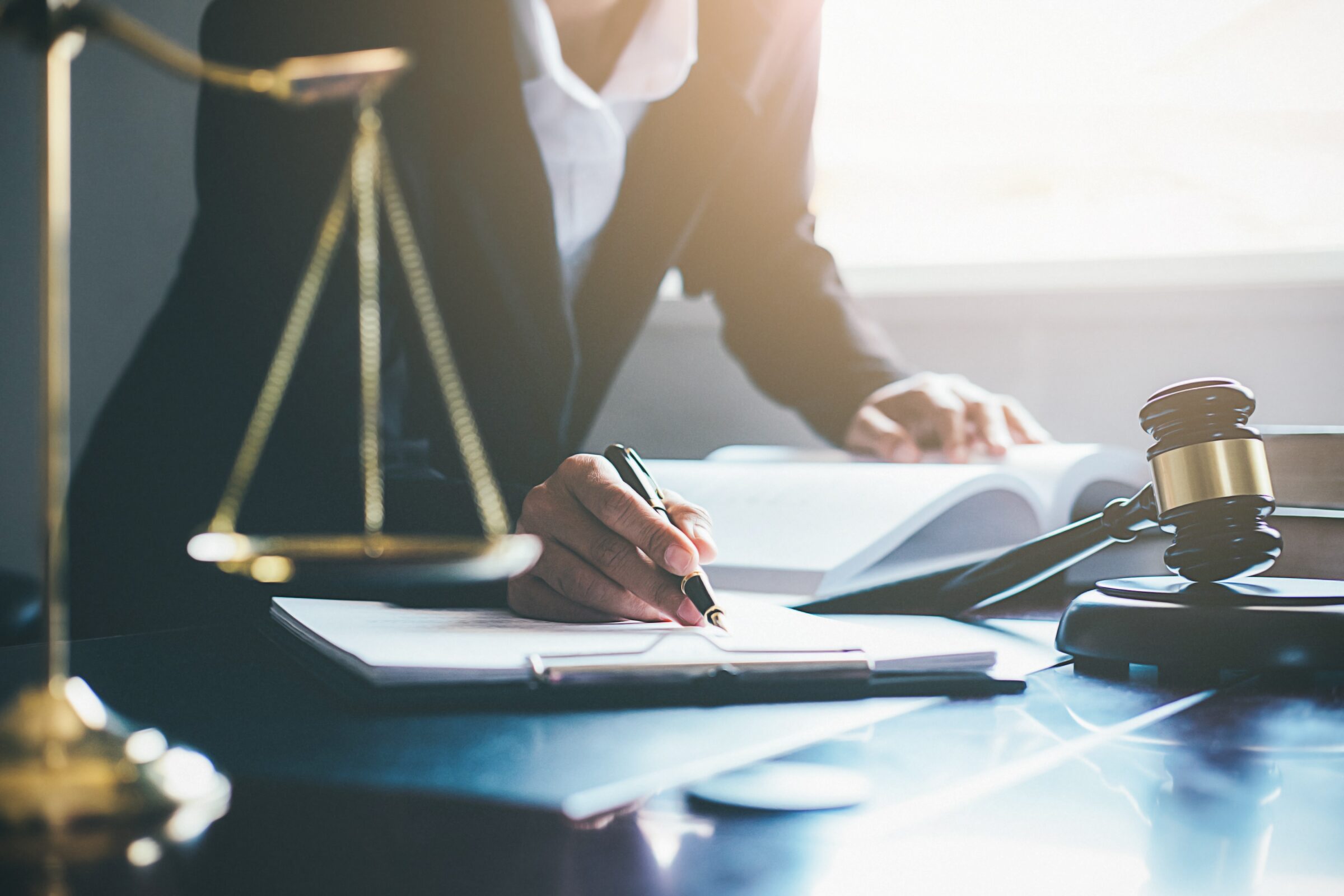 Woman writing at legal desk representing frequently asked questions about personal injury law