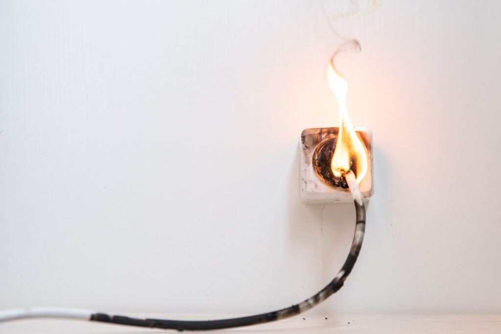 A plug catching fire while plugged into an outlet