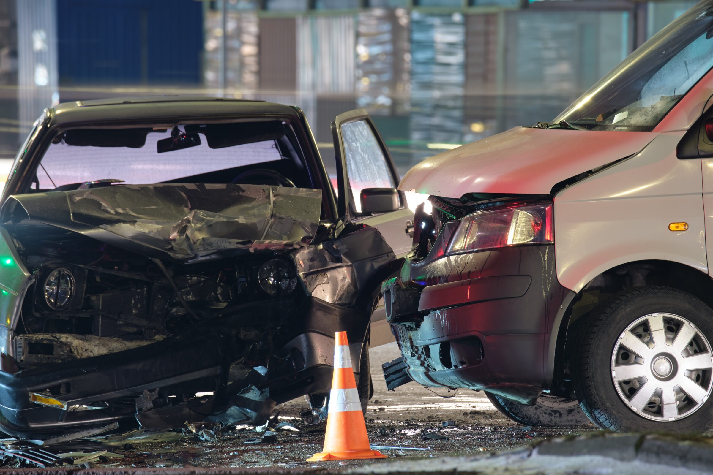 car accident scene with orange cones and broken car parts. a good car accident lawyer can investigate your crash, handle insurers, and secure maximum compensation.