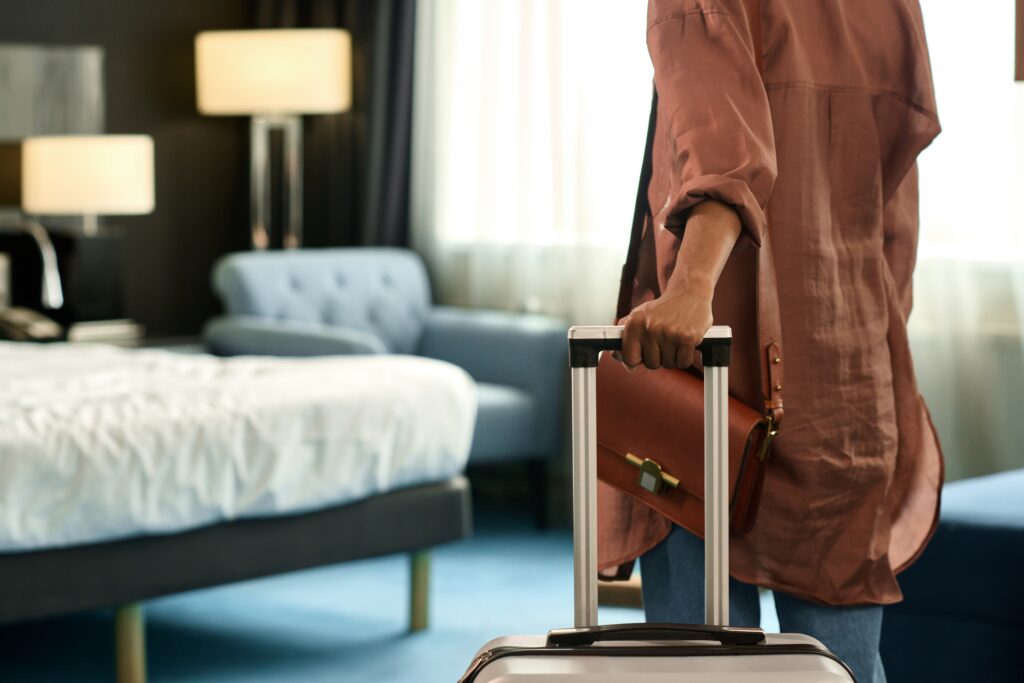hotel guest walking their suitcase into their room