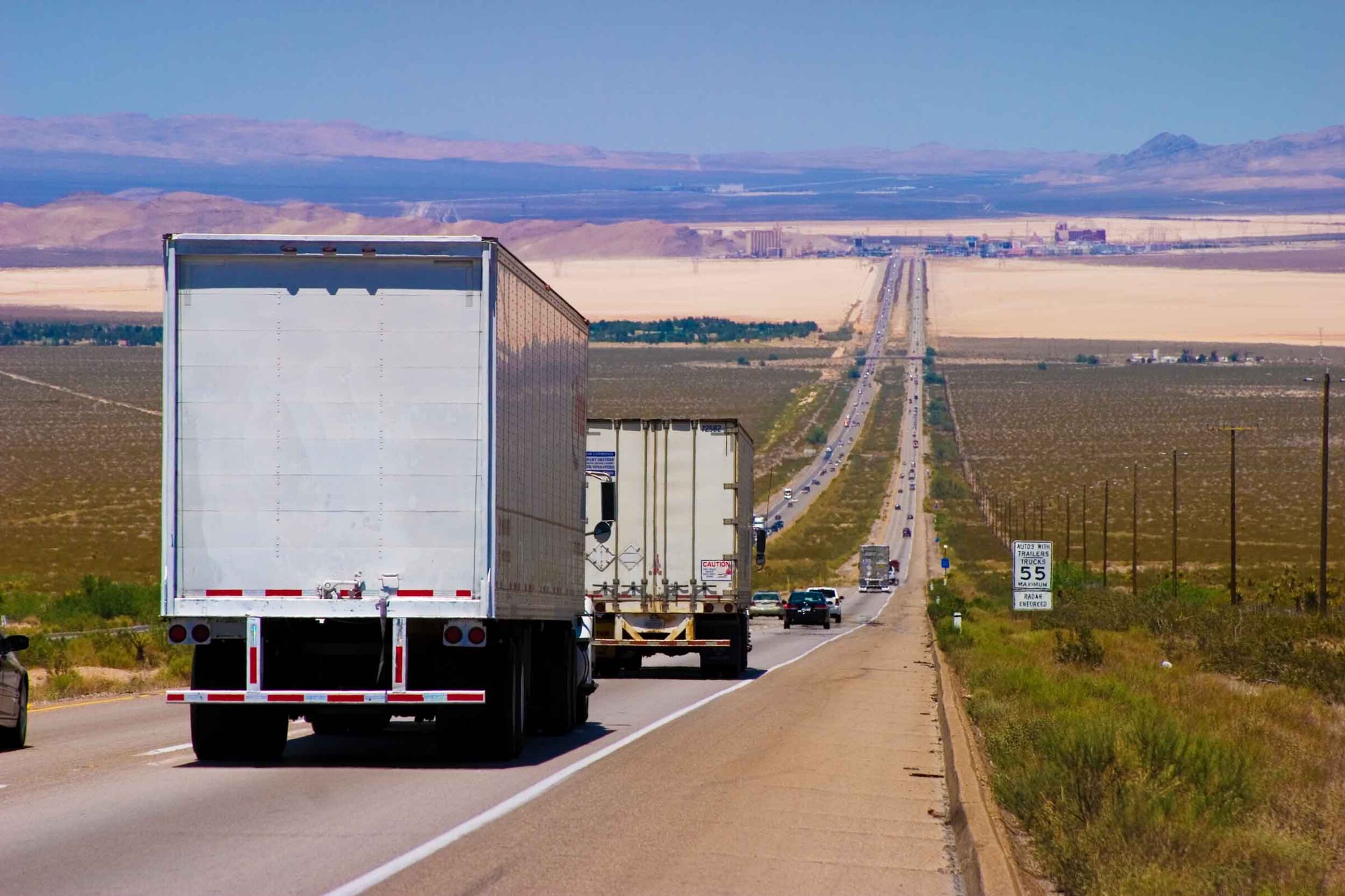 Interstate delivery trucks on a highway.