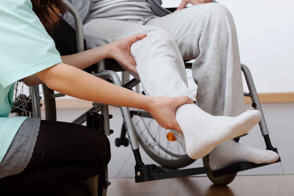 Young physiotherapist exercising with elder injured person