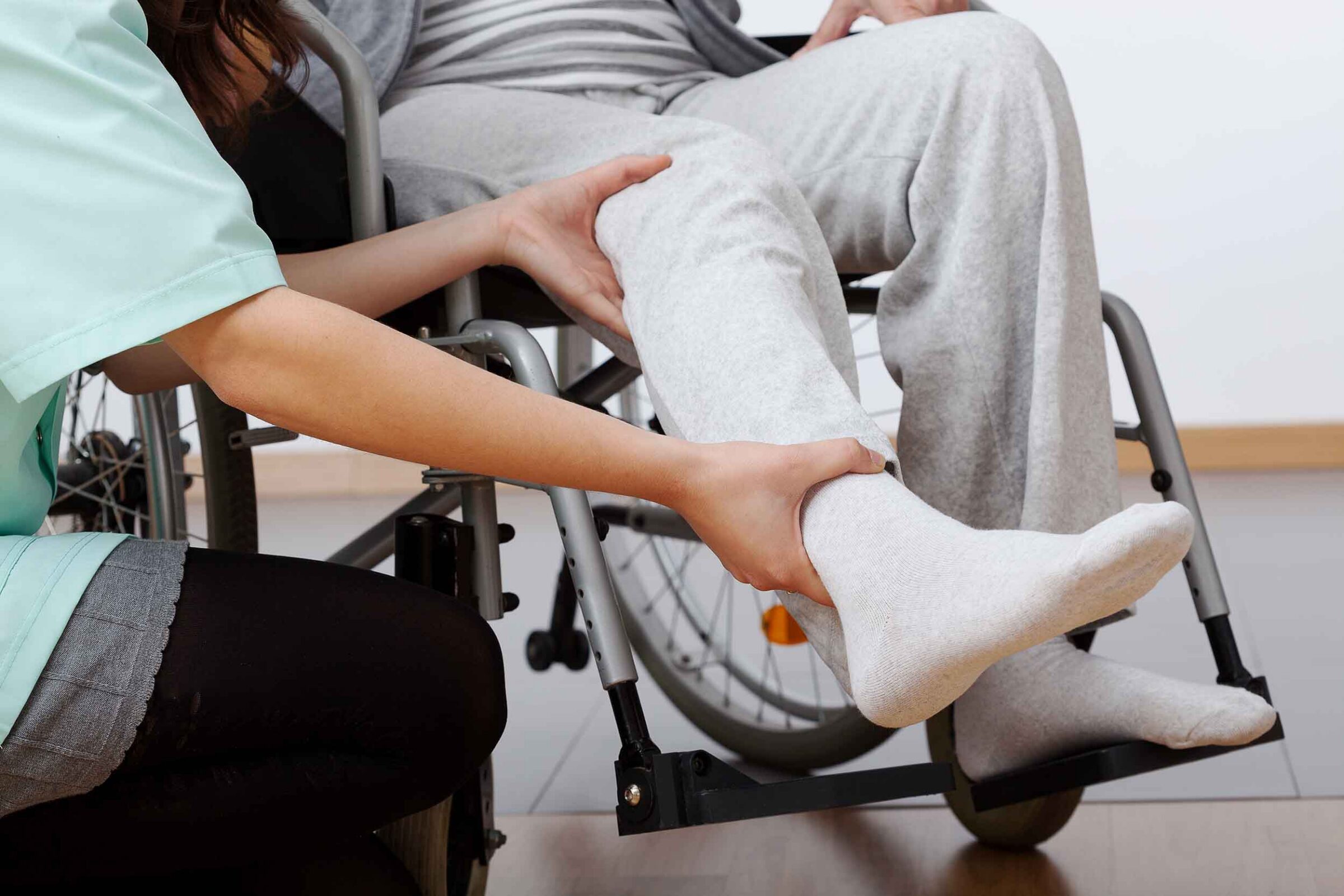 Young physiotherapist exercising with elder injured person
