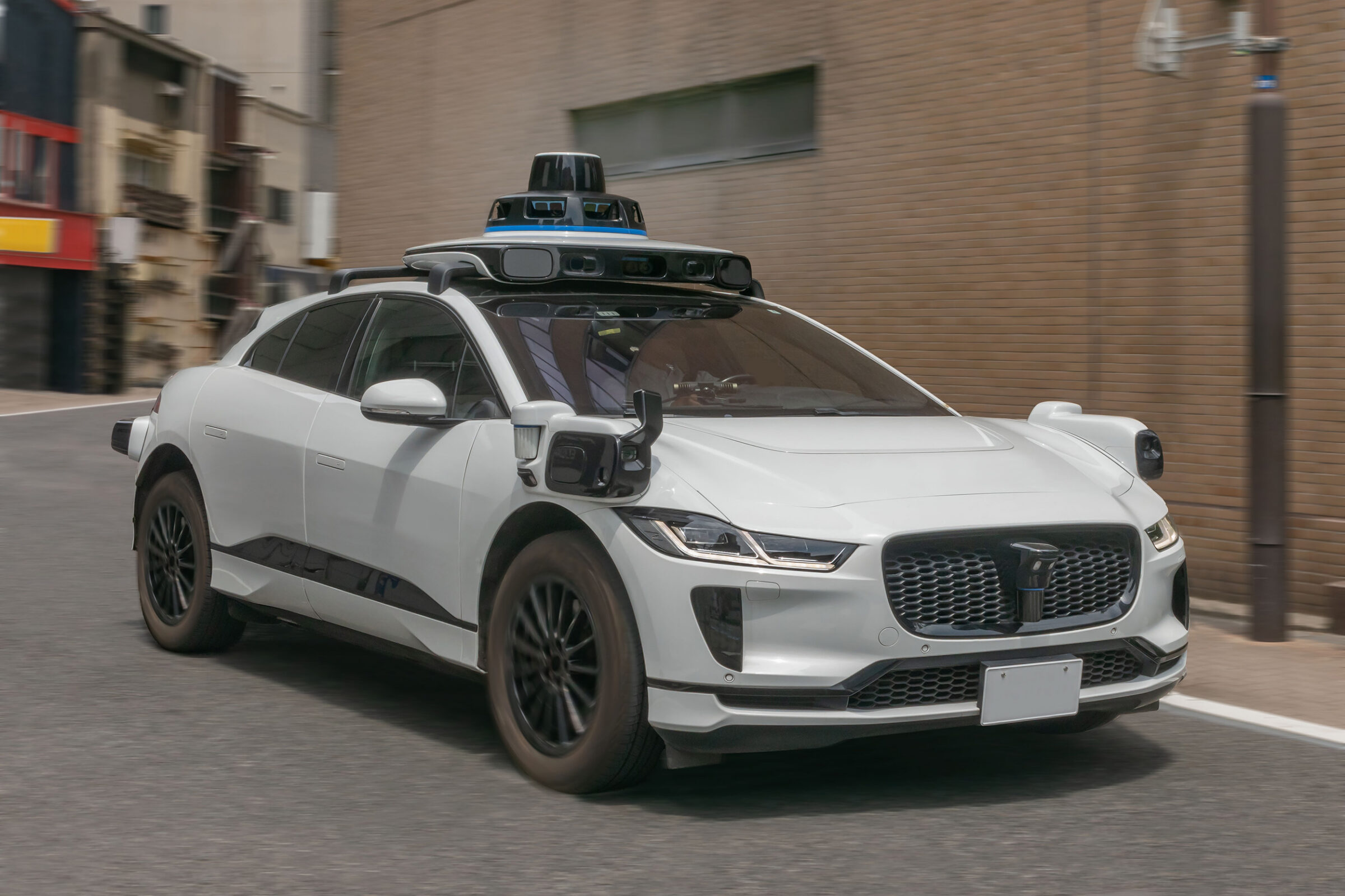 Self-driving sedan car with sensors and cameras to watch surroundings