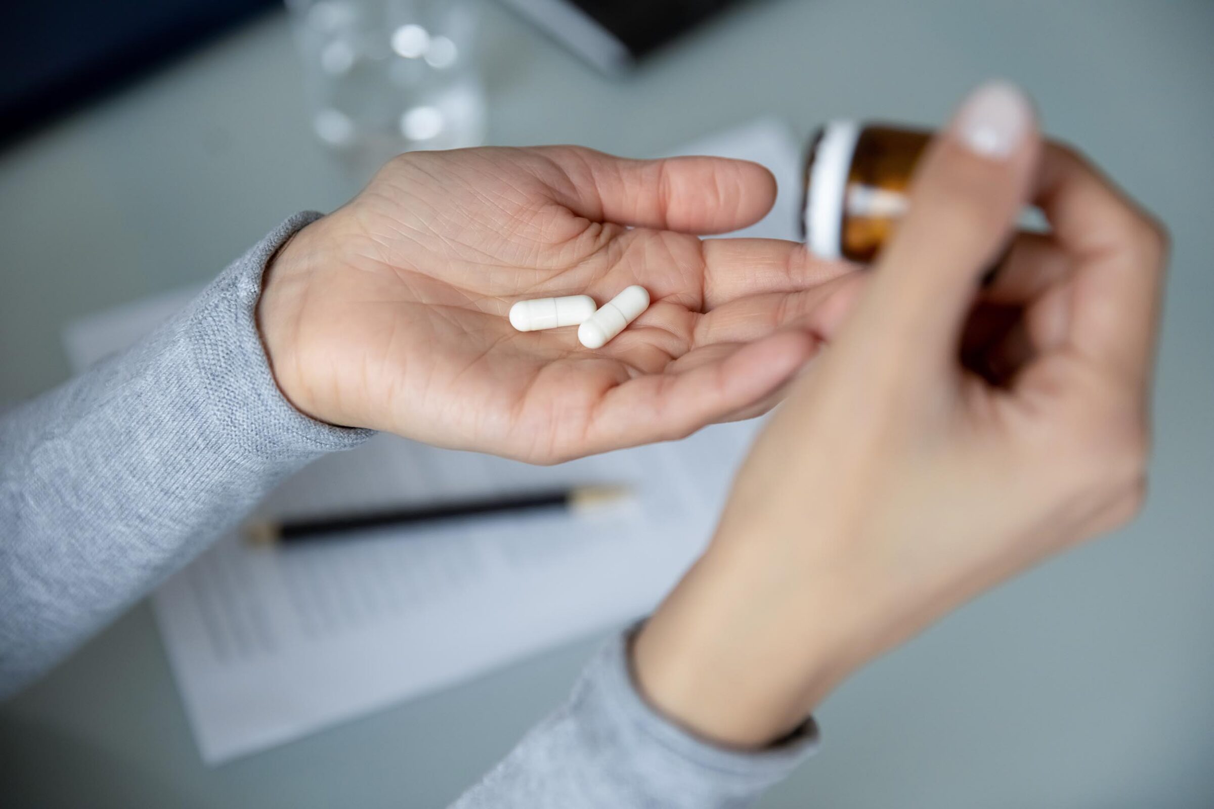 Close up top view of unhealthy woman's hands taking medicines
